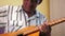 Elderly cheerful Caucasian man plays the guitar. Retired with an acoustic guitar. Leisure of an elderly person. Selective focus, m