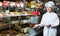 Elderly cheerful positive seller with dark and white chocolates