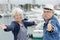 Elderly couple arms open on port