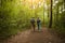 Elderly couple with backpack hiking in forest.