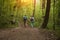 Elderly couple with backpack hiking in forest.