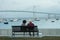 Elderly Couple on Bench Watching Harbor Boats