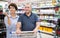 Elderly couple buys wine in the alcoholic section of a supermarket