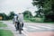 An elderly couple carefully cycled together on the highway, with their husband taking care of them behind them.Concepts about