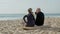 Elderly couple drinking tea on beach after surf training