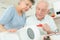 Elderly couple fixing coffee maker