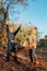 Elderly couple happily throws autumn fall leaves sitting in a park. Positive emotions of the elderly