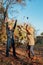 Elderly couple happily throws autumn fall leaves sitting in a park. Positive emotions of the elderly