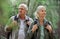 Elderly couple, hiking and active seniors in a forest, happy and relax while walking in nature. Senior, backpacker and