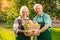 Elderly couple holding apple basket.