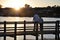Elderly couple on the lake deck watching the sunset