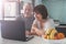 Elderly couple looking at computer in the kitchen