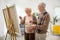 Elderly couple painting on a canvas