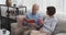 Elderly couple reading book and drinking coffee on sofa