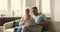 Elderly couple receive great proposition sitting on sofa before laptop