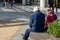 An elderly couple sat on a bench talking at a shopping mall or shopping centre