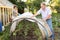 Elderly couple sets a greenhouse at a garden plot