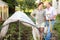 Elderly couple sets a greenhouse at a garden plot