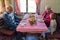 Elderly couple shares a heartwarming meal with their grandchild, creating cherished memories and enjoying the simple