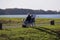 An elderly couple sits on chairs on the bank of the Rhine in the sun