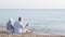 elderly couple sitting on a beach