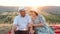 Elderly couple at the summer picnic at sunset.