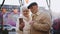 An elderly couple talking on a video call using a phone, standing on a street