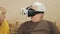 Elderly couple tries glasses virtual reality at home. The man wears glasses and they laugh at what is happening. high