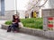 Elderly couple waits for bus next to daffodils and sakura, Nagoya, Japan