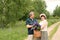 An elderly couple walks through the forest and a man gives a woman a woven basket with a bouquet of flowers of purple lupines