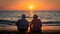 elderly couple watching the sunset on the beach