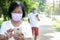 Elderly couples wear cloth masks Talk on the phone to prevent the spread of the virus.