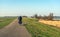 Elderly cyclist on a winding Dutch dike