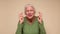An elderly European woman crosses her fingers for good luck