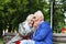 Elderly family couple talking on a bench in a city park. Happy seniors dating