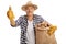 Elderly farmer holding a burlap sack and giving a thumb up