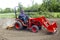 Elderly Farmer Tilling His Garden With A Compact 4x4 Tractor