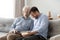 Elderly father grownup son laughing eating popcorn enjoy weekends together