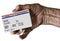An elderly female hand holds a mock United State government Medicare Health Insurance card. It is a generic card