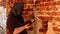 An elderly female priest in a black shawl reads a prayer.