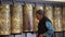 Elderly female rotating prayer wheels