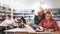 Elderly female teacher helps schoolgirl solve the equation in the school library