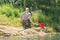 Elderly fisherman landing a fish in a fish net