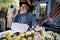 Elderly florist speaking on smartphone in flower shop