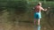 Elderly fly fisherman in a mountain river. Santa Claus summer vacation concept. Topless man in blue shorts with bare back throws a