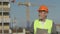 Elderly foreman in uniform against the background of a building under construction.