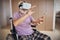 Elderly gamer in VR goggles sitting in the wheelchair