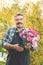 Elderly gardener with a bouquet of roses. elderly man with a beard holds a bouquet of pink roses cut in the garden