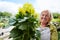 Elderly gardener with a geranium for an order