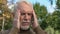Elderly gentleman feeling headache tension standing outdoors, health weakness